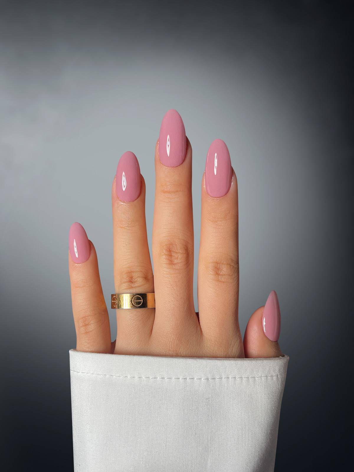 A hand showcases long nails wearing Mauve Majesty Dipping Powder by Sassy Saints – Brings The Salon Home, accented with a ring.