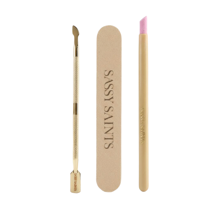 The Sassy Saints Perfect Prep Bundle (FREE) includes a gold cuticle pusher, a beige SASSY SAINTS nail file, and a gold cuticle remover tool with a pink tip, all shown on a white background.