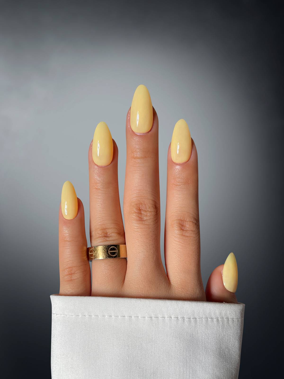 A hand with long nails painted in Vanilla Vixen Dipping Powder by Sassy Saints - Brings The Salon Home, adorned with a ring.