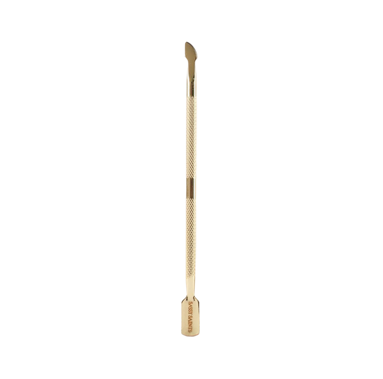 The Sassy Saints Gold Cuticle Pusher (FREE) features a textured grip, curved end for pushing back cuticles, and flat end for cleaning nails—perfect for dip powder manicures. Displayed on a plain white background.