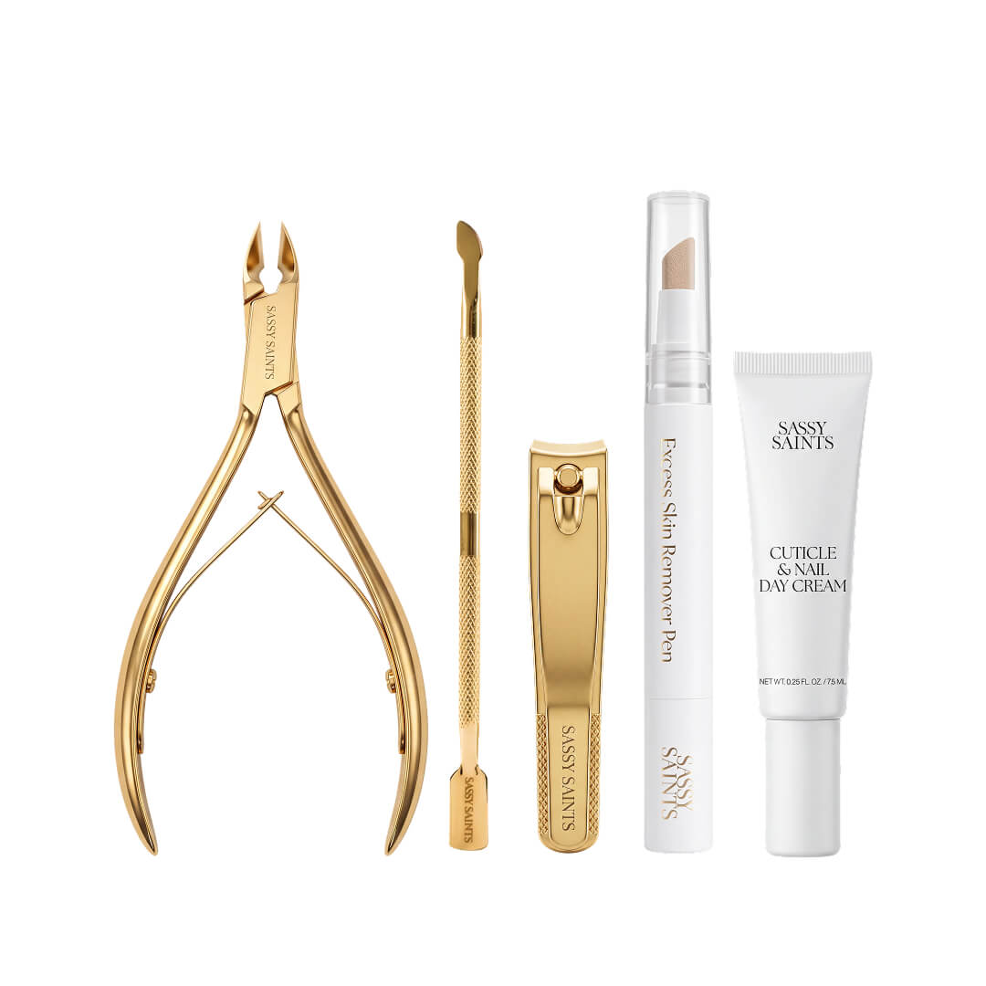 The Sassy Saints Perfect Cuticles Bundle includes gold-toned nippers, a pusher, and clippers, alongside an excess skin remover pen and a tube of cuticle and nail day cream.