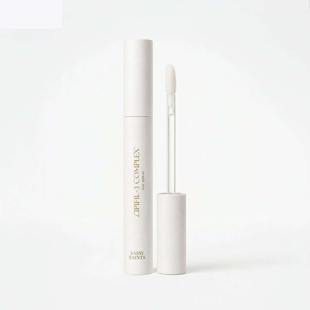 A white tube of Sassy Saints Cuticle Serum with its cap off, showing the wand applicator. The product stands upright against a plain white background.