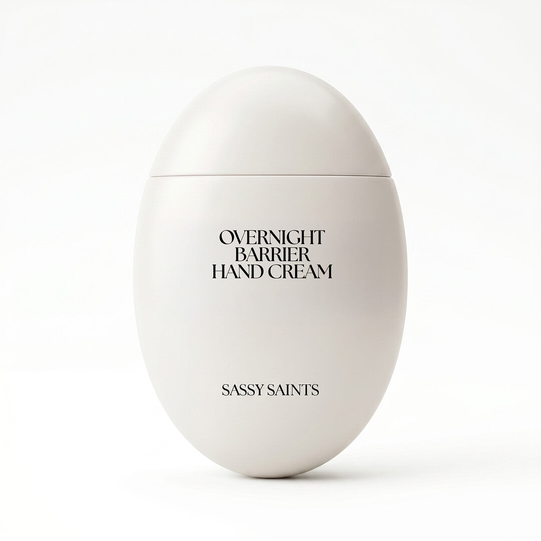 A white, oval-shaped container labeled "Overnight Barrier Hand Cream" is shown against a plain white background, with "Sassy Saints - Brings The Salon Home" displayed underneath.