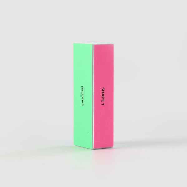 The Sassy Saints 4 Sided Nail Tool Buffer Block stands upright on a plain light background, showing its green SMOOTH 2 and pink SHAPE 1 sides.