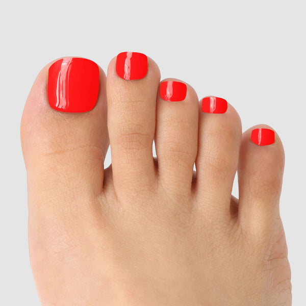 A close-up of toes featuring Sassy Saints' Hotline Edit Pedicure Gel Wrap, showcasing all nails in bold red against a light gray background.