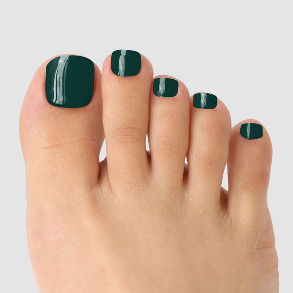 A close-up of a foot with neatly trimmed toenails wearing Sassy Saints’ Forest Green Pedicure Gel Wrap, bringing salon-quality glossy color to your nails, set against a plain light gray background.